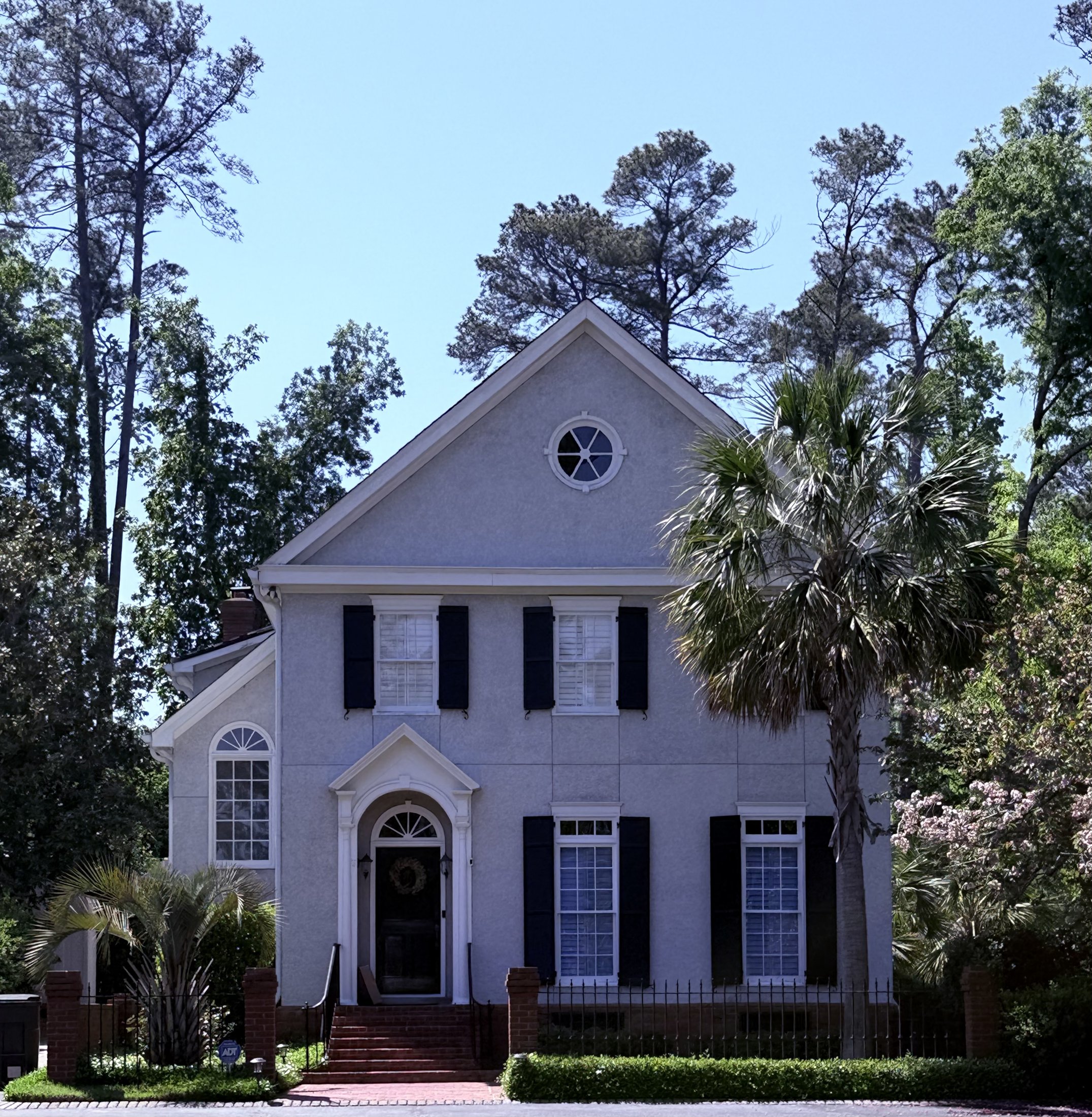 Brick Colonial home with a tall front-facing pediment gable and arched entry, Augusta, Georgia, architectural photography by Nelson White